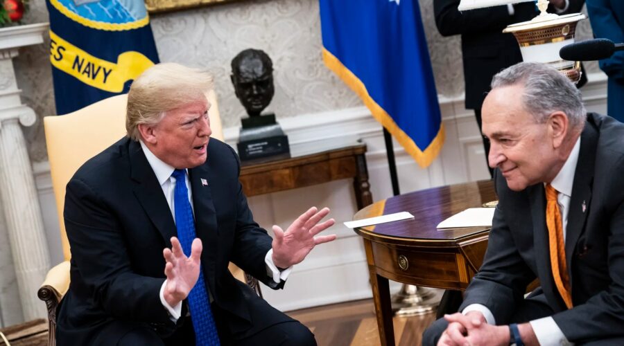 Sen. Chuck Schumer in the Oval Office with President Donald Trump. Schumer is smiling blandly as President Trump scowls.