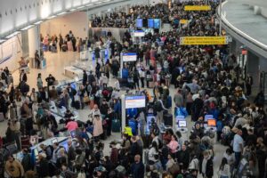 A photo of crushing crowds at an airport waiting in TSA lines.