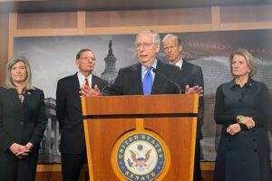 Sen. Mitch McConnell at a lectern, looking bug-eyed at something
